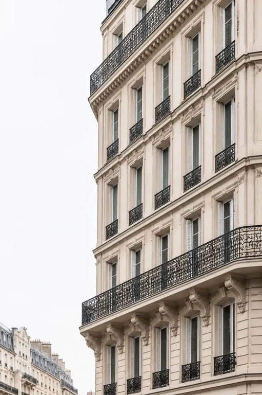 Acheter appartement haussmannien Paris : façade en pierre de taille avec balcons en fer forgé